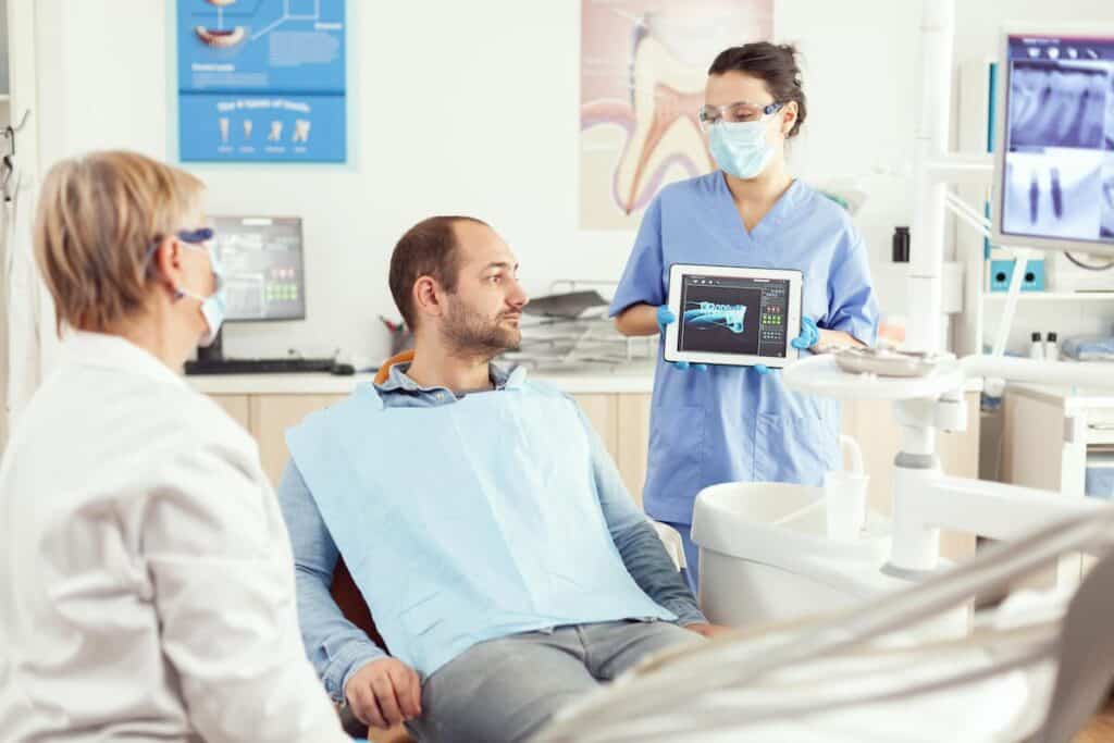 A person admiring their bright, white smile in a mirror after a successful teeth whitening treatment Basildon
